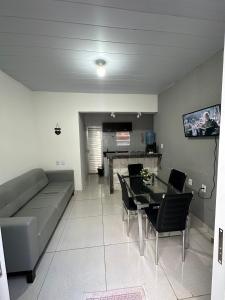 a living room with a couch and a table at Casa aconchegante Maragogi in Maragogi