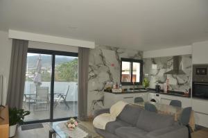 a living room with a couch and a kitchen at Moonfall House in Arco da Calheta