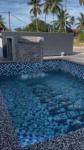a swimming pool with a blue and white tile at Nawra Homestay PCB in Kota Bharu