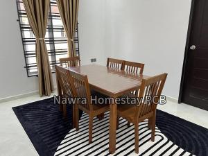 a wooden table and chairs in a room at Nawra Homestay PCB in Kota Bharu