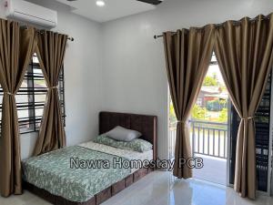 a bedroom with a bed and a balcony at Nawra Homestay PCB in Kota Bharu +10 photos