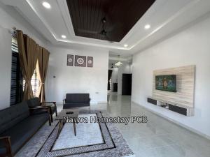 a living room with a couch and a tv at Nawra Homestay PCB in Kota Bharu
