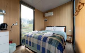 a bedroom with a bed with towels on it at Bruce Farm Alpaca Cabin 4 by Tiny Away in Balclutha