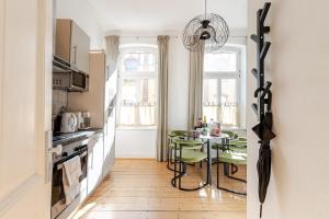 eine Küche mit einem Tisch mit grünen Stühlen und einem Esszimmer in der Unterkunft Sustainable Living - Haus Frieda in Bonn
