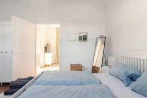ein weißes Schlafzimmer mit zwei Betten und einem Spiegel in der Unterkunft Sustainable Living - Haus Frieda in Bonn