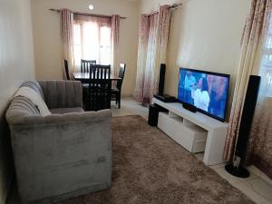 a living room with a couch and a flat screen tv at Blissful abode in Kisumu +1 photo