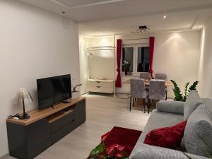 un soggiorno con un divano, una TV e un tavolo di WM GEDER Ferienwohnungen Villa Tanja a Lebring