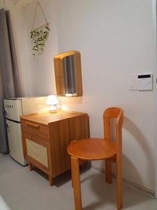 a small wooden table and a chair and a refrigerator at 스테이부산길 Stay Busan-gil Guesthouse Seomyeon Busan 