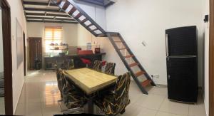 una mesa y sillas en una habitación con una escalera en Sungai Udang Homestay 4 bilik dengan 2 loteng atas, en Melaka