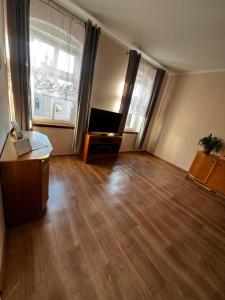an empty living room with a couch and a television at Apartament Wolności in Jaworzyna Śląska
