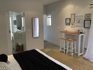 a bedroom with a bed and a kitchen with a counter at Namaste Cottage - Garden Facing 2-sleeper Hideaway in Paternoster