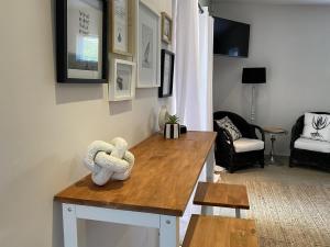 a living room with a table with two stuffed animals on it at Namaste Cottage - Garden Facing 2-sleeper Hideaway in Paternoster