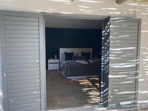 a bedroom with a bed and blue walls at Namaste Cottage - Garden Facing 2-sleeper Hideaway in Paternoster