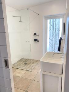 a white bathroom with a sink and a shower at Namaste Cottage - Garden Facing 2-sleeper Hideaway in Paternoster +29 photos