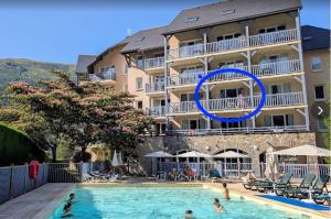 a hotel with a swimming pool in front of a building at Appartement 203 in Saint-Lary-Soulan