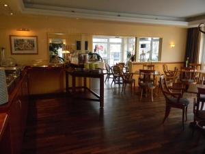a restaurant with a bar and tables and chairs at Hotel Stadt Norderstedt in Norderstedt