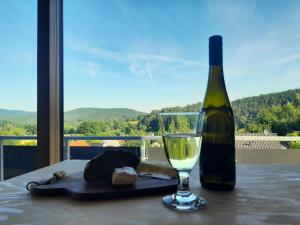 a bottle of wine and a glass on a table at Rausblick Cabin in Bruchweiler-Bärenbach