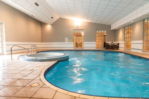 a large indoor pool with blue water in a building at Milton Hill House in Abingdon