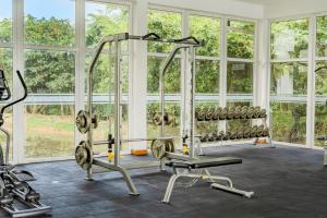 a gym with several tread machines and windows at Ten4teen Luxury Apartment in Galle