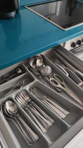 a drawer filled with silver utensils in a kitchen at El jardín de Max, apartamento céntrico con jardín privado y parking in Comillas
