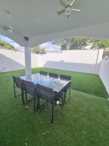 a table with four chairs under a white umbrella at Hidden Gem between Waves & Mountains in Lo Gea