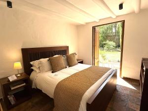 a bedroom with a large bed and a large window at Hotel Casa Terra in Villa de Leyva