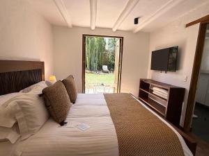 a bedroom with a large bed and a television at Hotel Casa Terra in Villa de Leyva +95 photos