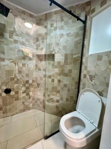 a bathroom with a toilet and a glass shower at Affordable room near the beach in San Felipe de Puerto Plata
