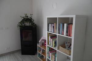 a book shelf filled with books next to a tv at Casa Alla Veduta in Trento