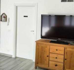 a flat screen tv sitting on top of a wooden dresser at Casa Alla Veduta in Trento