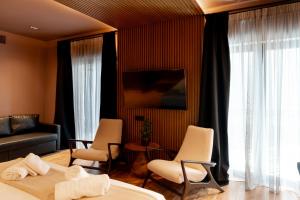 a living room with a bed and chairs and a couch at Ode Aristofanous - Urban Boutique Hotel in Athens