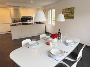 a white dining room table with white chairs and a white at Ferienhaus Birds No 11 Lauchringen in Lauchringen