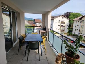 a balcony with a blue table and chairs at Appartement F3 Carolina - Triangle Annecy, Chamonix, Genève in Reignier