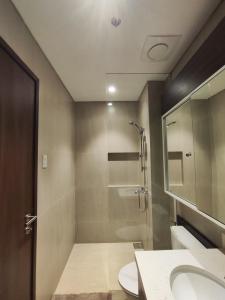 a bathroom with a shower and a toilet and a sink at Tiny Oasis at Tambuli Seaside Living in Maribago