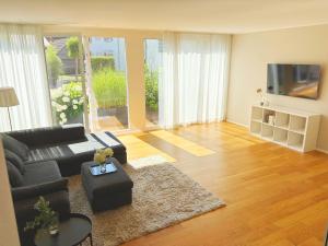 a living room with a black couch and a tv at Ferienhaus Birds No 11 Lauchringen in Lauchringen