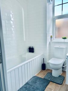 ローチェスターにあるStrood Modern One Bed close to Castle and Dockyard - Flat 1の浴槽とトイレのある白いバスルーム +8枚の写真
