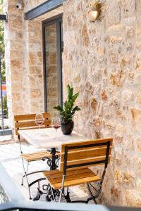 a table with two wine glasses and a potted plant at Ode Aristofanous - Urban Boutique Hotel in Athens