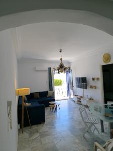 een woonkamer met een blauwe bank en een glazen tafel bij Appartement vue mer à Cap Gammarth in Gammarth
