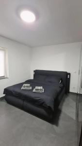 a bedroom with a black bed with two towels on it at Luxury Apartment in Herne