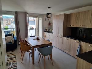 a kitchen and dining room with a table and chairs at Appartement F3 Carolina - Triangle Annecy, Chamonix, Genève in Reignier