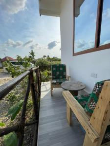キウェンワにあるAsili Nyumbani Residenceのバルコニー(テーブル、椅子付)、窓が備わります。