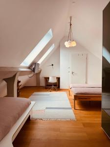 a attic bedroom with two beds and a window at Exklusives Penthouse im ehemaligen Bunker in Hannover