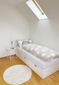 a white bedroom with a bed and a white rug at Ferienhaus Birds No 11 Lauchringen in Lauchringen