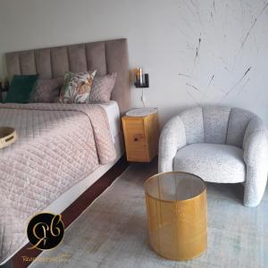 un dormitorio con una cama y una silla en Rearabetsoe Guest House, en Maputsoe