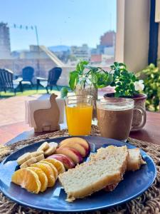 Un plato azul de comida con sándwiches y jugo de naranja. en La salteñita alojamiento, en Salta 37 fotos más