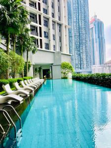 ein Pool in der Mitte eines Gebäudes mit Stühlen in der Unterkunft The Mews KLCC Service Suites in Kuala Lumpur