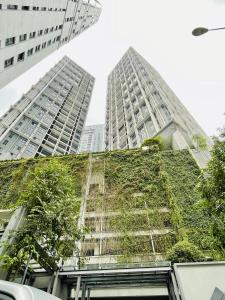 ein Gebäude mit einem Gründach mit zwei hohen Gebäuden in der Unterkunft The Mews KLCC Service Suites in Kuala Lumpur