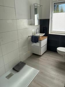 a bathroom with a sink and a toilet at Ferienwohnung -Diemelaue- in Warburg