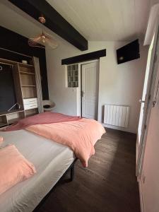 a bedroom with a bed with pink sheets and a fan at Chambre indépendante au pied de la Rhune in Urrugne