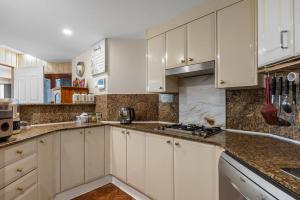 a kitchen with white cabinets and marble counter tops at 72-2HS Abnb-Style Urban Pearl, Parking, Pool and Step to Darling Harbour in Sydney